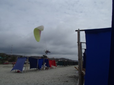 A paraglider taking off from the beach - a common sight in Canoa